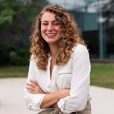 A professional headshot of Alexandra Aiello - AT, RMT. Alex is laughing in the picture.